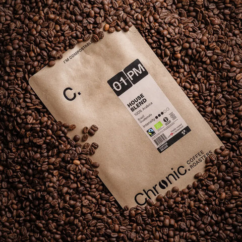 Paquet de café Chronic. 01PM 1kg sur fond de café torréfiés