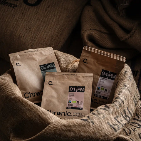 paquets de cafés Chronic. posés dans un sac de café vert
